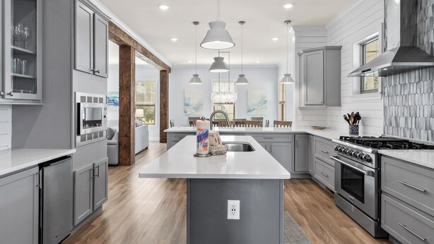 A modern kitchen with grey cabinetry, a central island, stainless steel appliances, pendant lighting, and a view to the dining area. - Bike, EV Charger, New Rental! Golf Cart Included, Pool, 30A (Santa Rosa Beach)