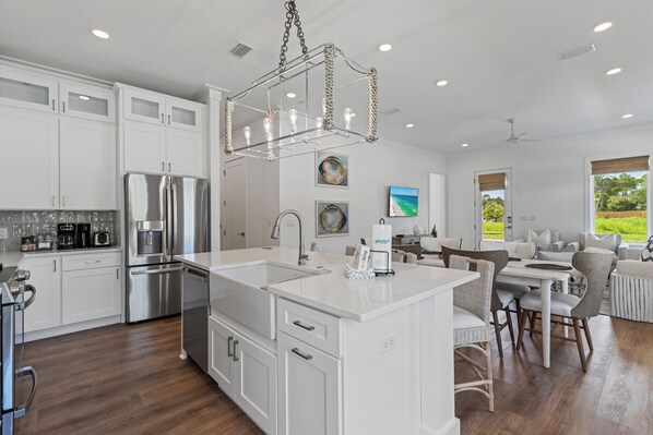 A modern kitchen with white cabinetry, stainless steel appliances, and a central island.