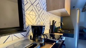 A modern kitchen with a built-in oven, a coffee maker, and a microwave.
