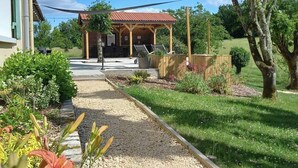 A covered outdoor seating area with a gravel path leading to a building. - Luxury Holiday Home Paulhiac - Large Pool (Paulhiac)