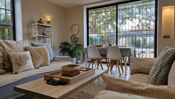 A modern living room with a sofa, coffee table, and dining area. - Le Champ du Roy (Chasse-sur-Rhône)
