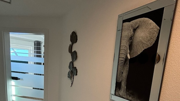 A hallway with a wooden floor, a door leading to a balcony, and a framed picture on the wall. - Gemütliche Naturnahe Ferienwohnung in Oberbayern "Am Weiher" (Denklingen)