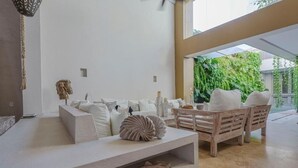 A modern living room with a white sofa set, a wooden coffee table, and decorative shells. - Casa Charlies Can (Cartagena)