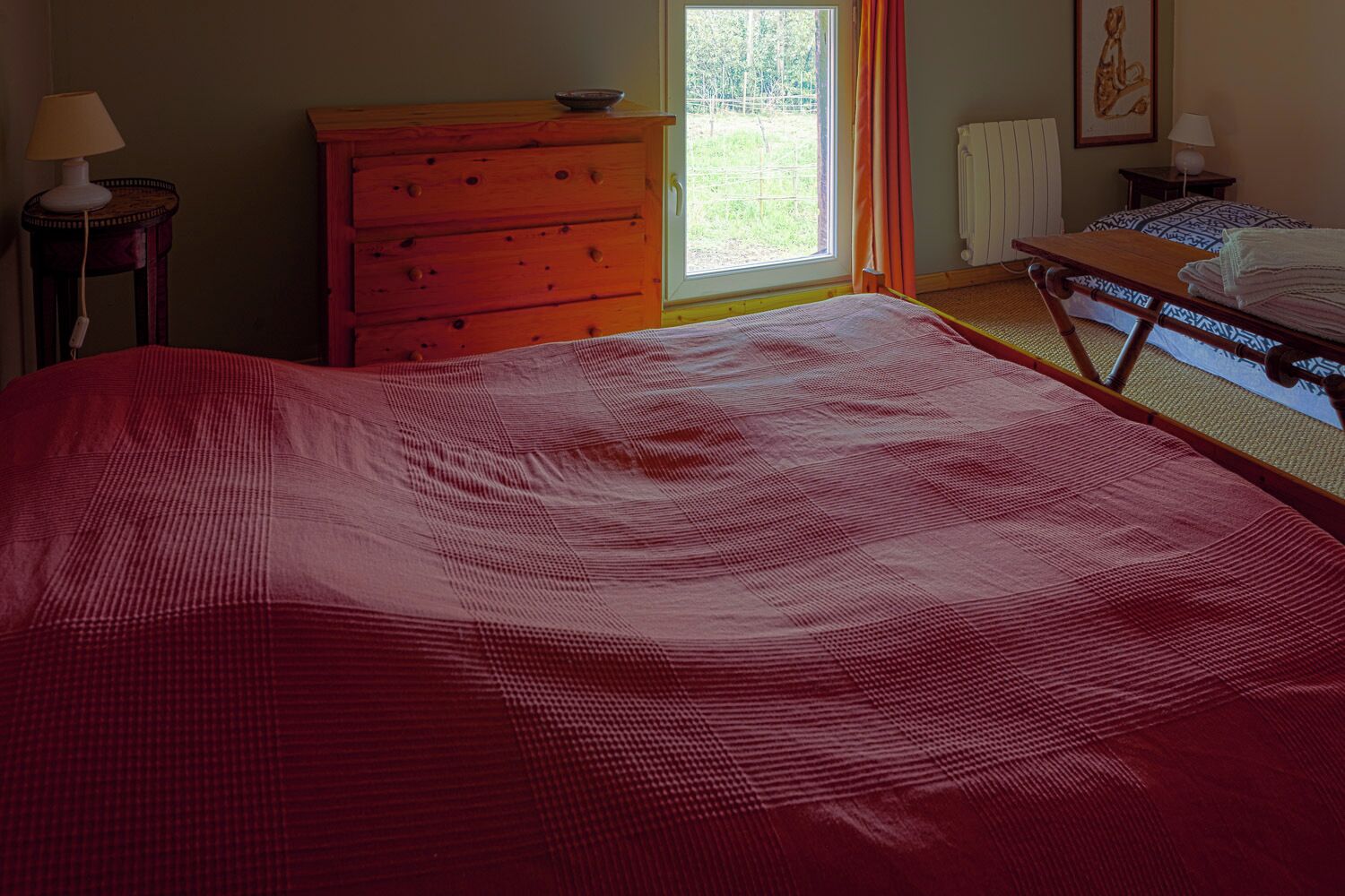 Una camera da letto con un letto grande, una cassettiera, un tavolo e una finestra con vista.