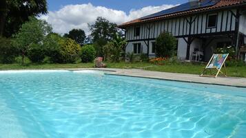 Una piscina al aire libre de temporada, sombrillas