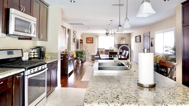 A spacious kitchen with granite countertops, stainless steel appliances, and pendant lighting. - Charming Craftsman Retreat: 3BR Home w/ Pool & Jacuzzi – Your Perfect Getaway! (Bonita)