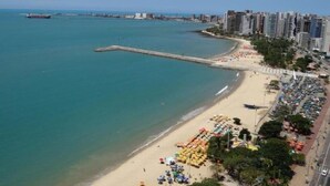 A coastal cityscape with a sandy beach, a long pier, and high-rise buildings. - Beira Mar Fortaleza Landscape Luxo (Meireles Fortaleza)