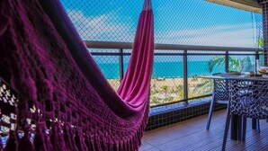 A hammock on a balcony with a view of the ocean. - Beira Mar Fortaleza Landscape Luxo (Meireles Fortaleza)