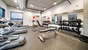 A gym with treadmills, a bench press, and a rack of dumbbells.