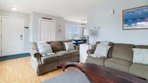 Ein Wohnzimmer mit zwei Sofas, einem Couchtisch und einem Esstisch.