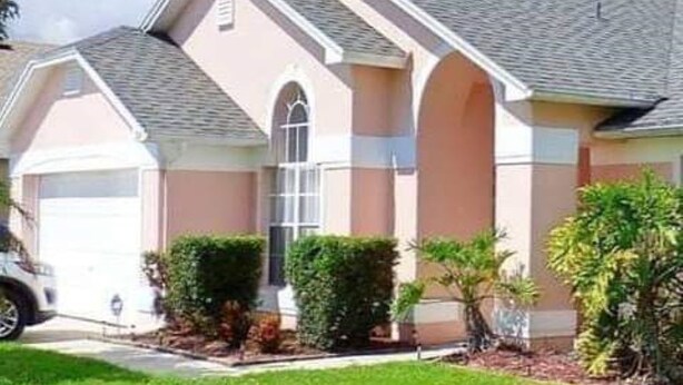 A single-story house with a garage, a sloped roof, and a well-maintained lawn.