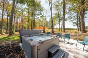 Ein Whirlpool in bewaldeter Landschaft mit Sitzgelegenheiten im Freien.