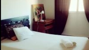 A hotel room with a single bed, a nightstand, a lamp, and a painting on the wall. - 🌴 Typical Riad | Historic Center 🏡 Private Terrace | Wi-Fi + Air Conditioning (Marrakech)