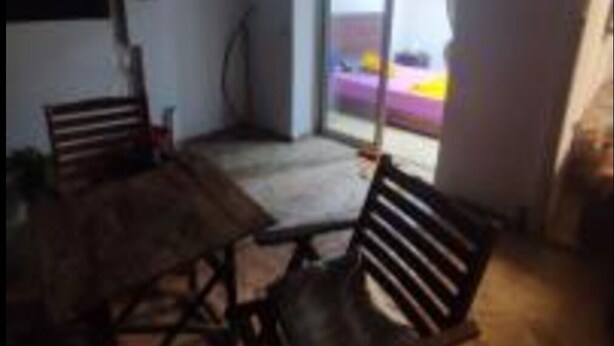 A room with a wooden table and chairs, a sliding glass door leading outside, and a ceiling fan. - 🌴 Typical Riad | Historic Center 🏡 Private Terrace | Wi-Fi + Air Conditioning (Marrakech)