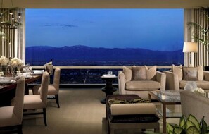 Relax in this stylish lounge area with a breathtaking mountain view, featuring a dining table, comfortable seating, and a balcony with unobstructed views.