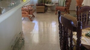 Ein Wohnzimmer mit Essbereich, einer Treppe und Blick ins Freie.