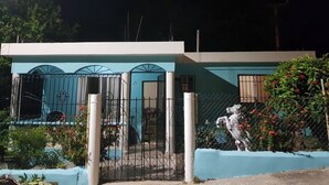 Ein zweistöckiges Gebäude mit hellblauer Fassade, einem verschlossenen Eingang und einer Pferdestatue.