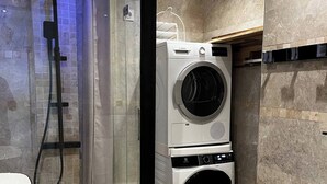 A modern bathroom with a glass-enclosed shower, a Bosch washing machine, and a sink. - Cosy apartment with views over Paris (Le Kremlin-Bicêtre)