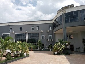 A hotel with a modern design, featuring large windows and air conditioning units.