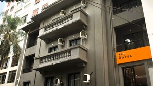 A hotel building with multiple balconies, air conditioning units, and a sign indicating it is a Unity Hotel. - Unity Hotel Paulista (São Paulo)