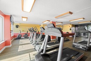 Academia com esteiras, elípticos e bicicletas de exercício.