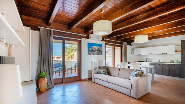 A modern living room with a sofa, a dining area, and a kitchen. - 'Attico da Mare 14' Apartment with Private Terrace, Wi-Fi and Air Conditioning (Polignano a Mare)