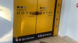 A hotel entrance with the name 'Unity Hotel' and contact numbers. - Unity Hotel Votorantim (Votorantim)
