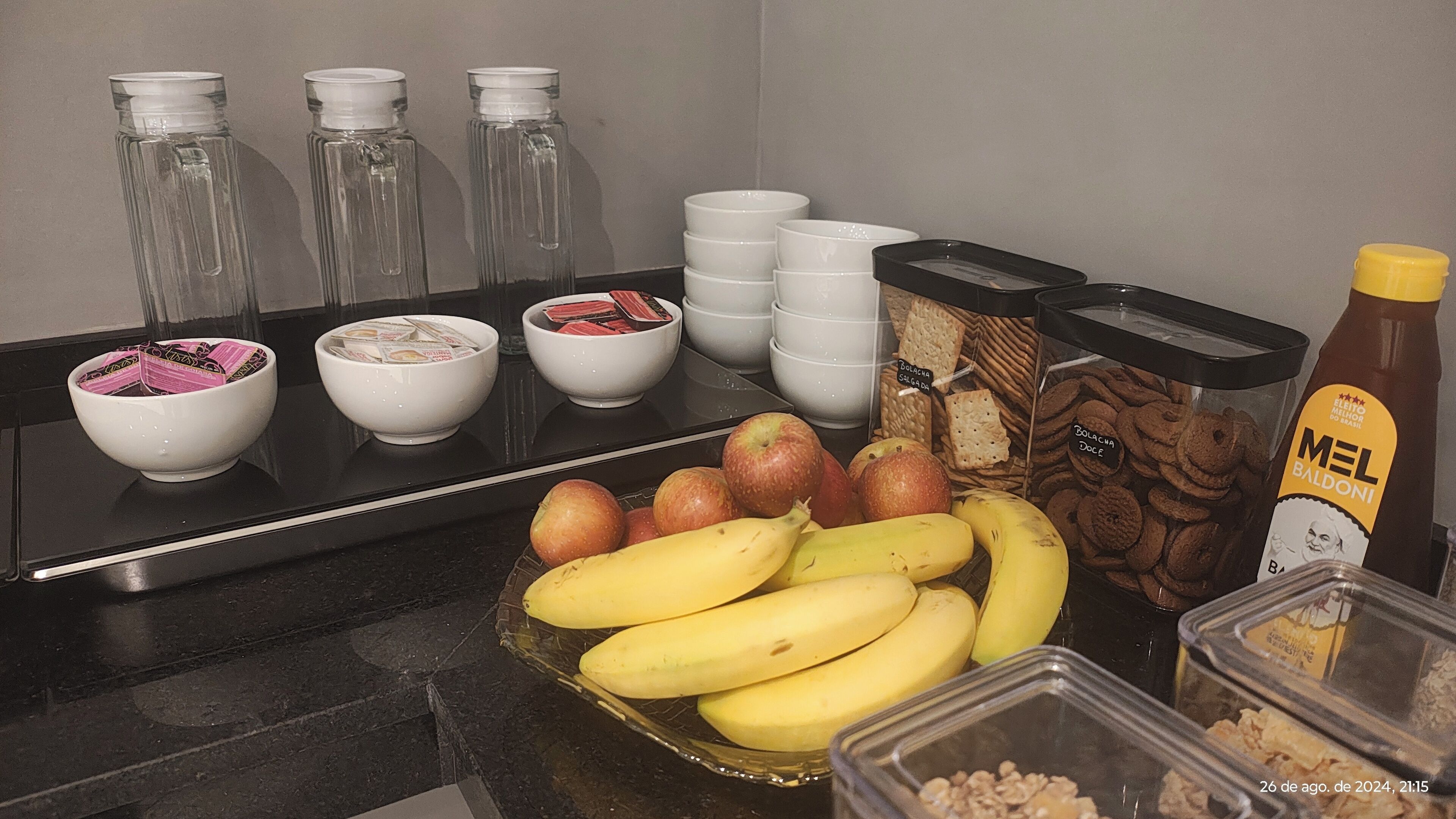 A kitchen counter with various food items including bananas, apples, and packaged goods.