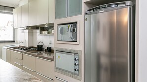A modern kitchen with built-in appliances, including a stainless steel refrigerator, oven, and microwave.