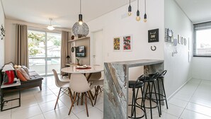 A modern kitchen with a marble island, bar stools, and pendant lighting.