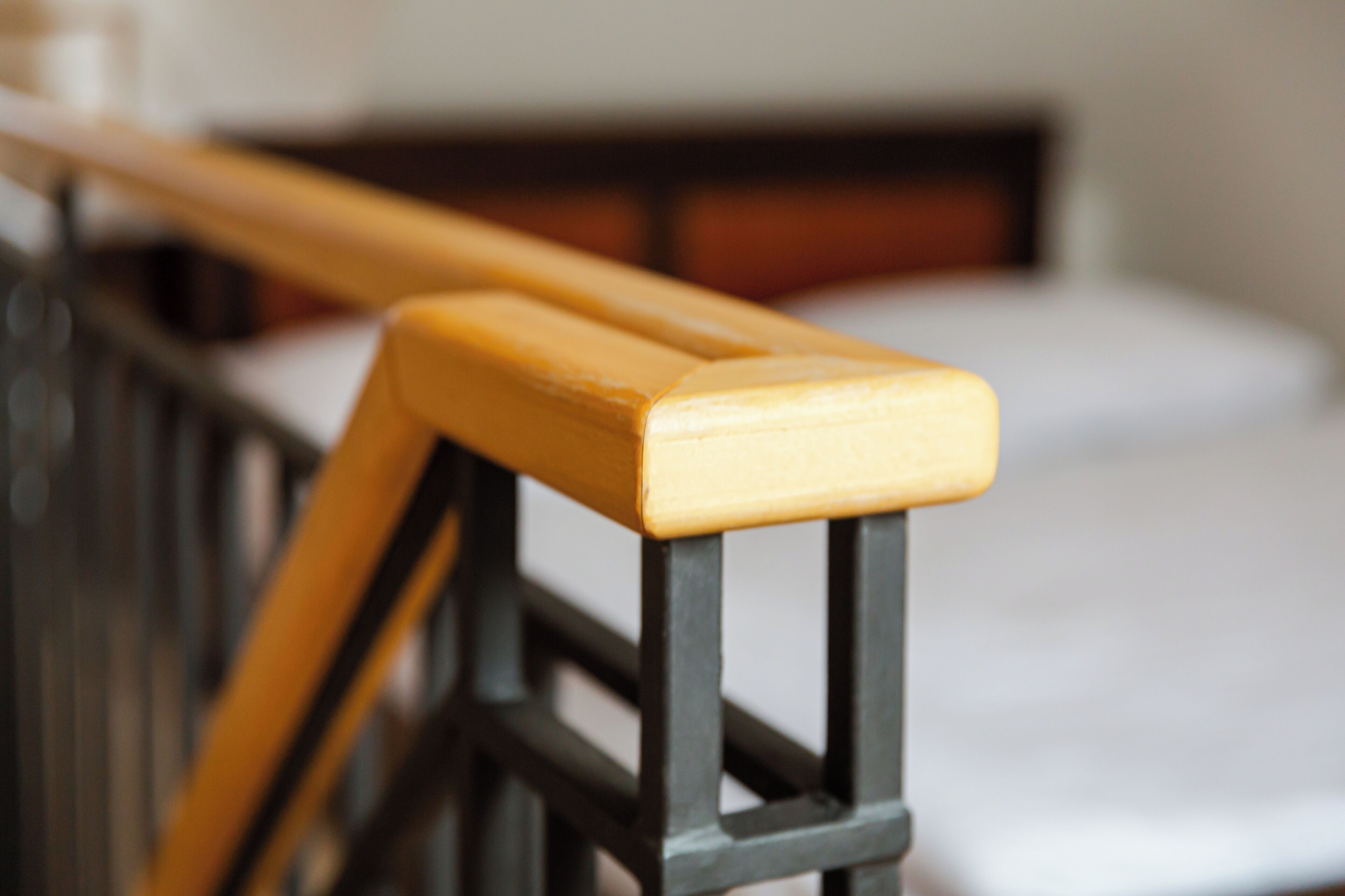 Primer plano de una barandilla de madera con estructura metálica negra.
