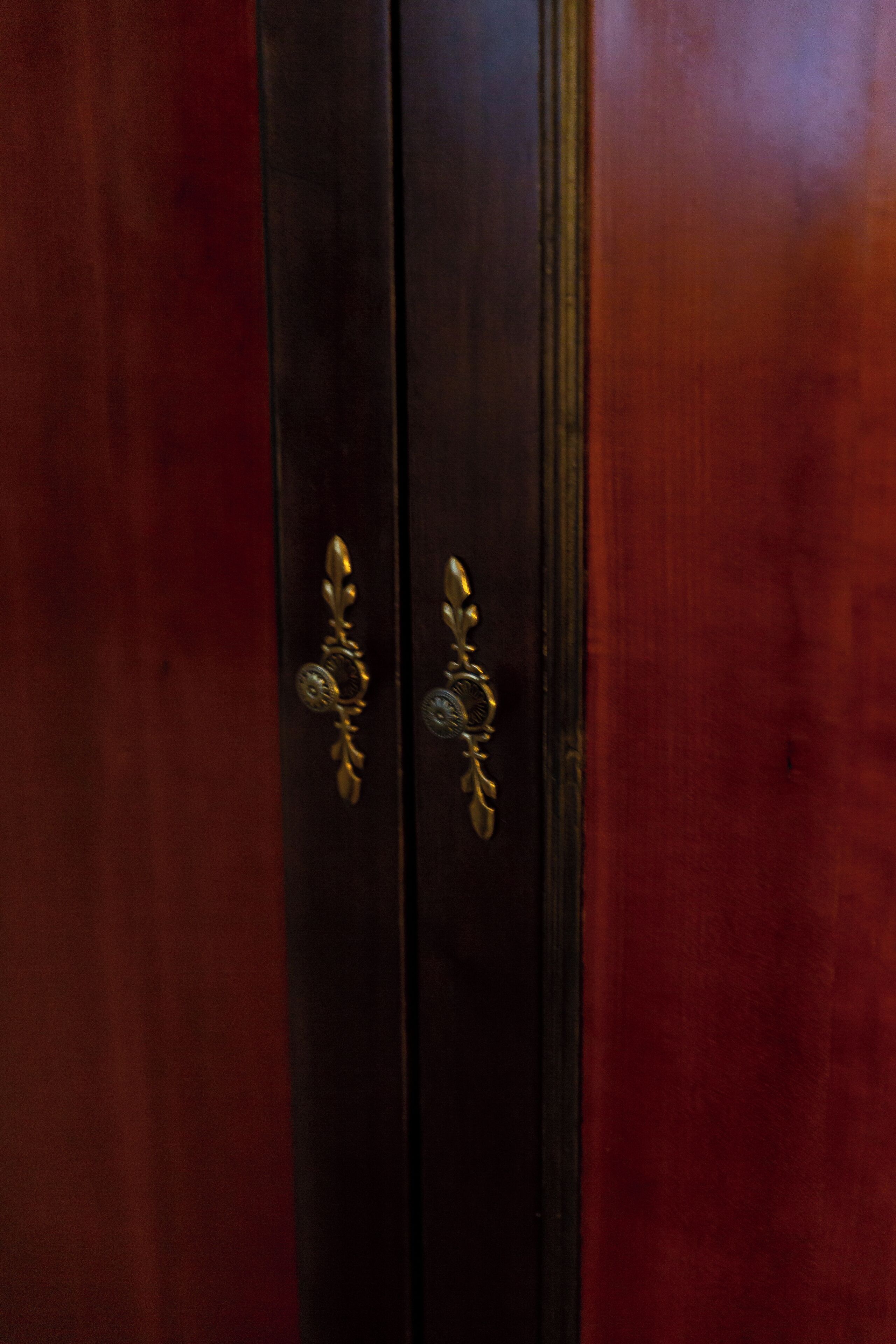Una puerta de madera oscura con detalles de latón labrados.