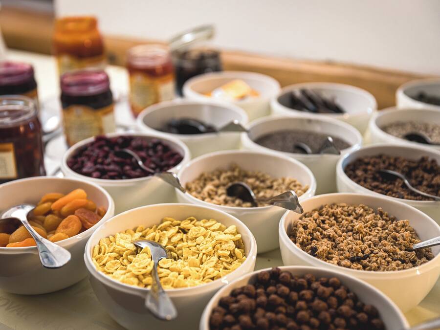 A variety of food items in bowls, including cereals and dried fruits.
