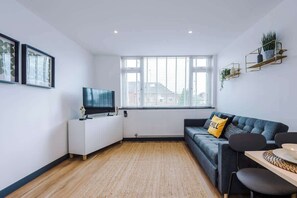 A modern living room with a sofa, TV, and a dining area. - Perfect for Contractors/Long Stays/Close Amenities (Cheshire West and Chester)