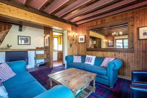 A cozy room with a blue sofa, a wooden coffee table, and a fireplace.