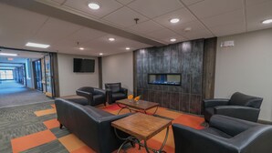 Ein Konferenzraum mit Ledersofas, einem Holztisch und einem Kamin.
