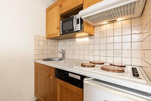 A compact kitchen with a microwave, sink, and stove.