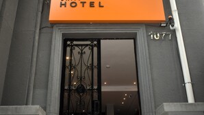 A hotel entrance with an orange sign reading "UNITY HOTEL" and the address "1077". - Unity Hotel Campinas (Campinas)