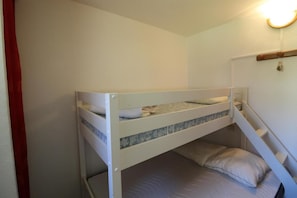 Uma cama beliche com uma pequena escada que leva ao colchão superior.