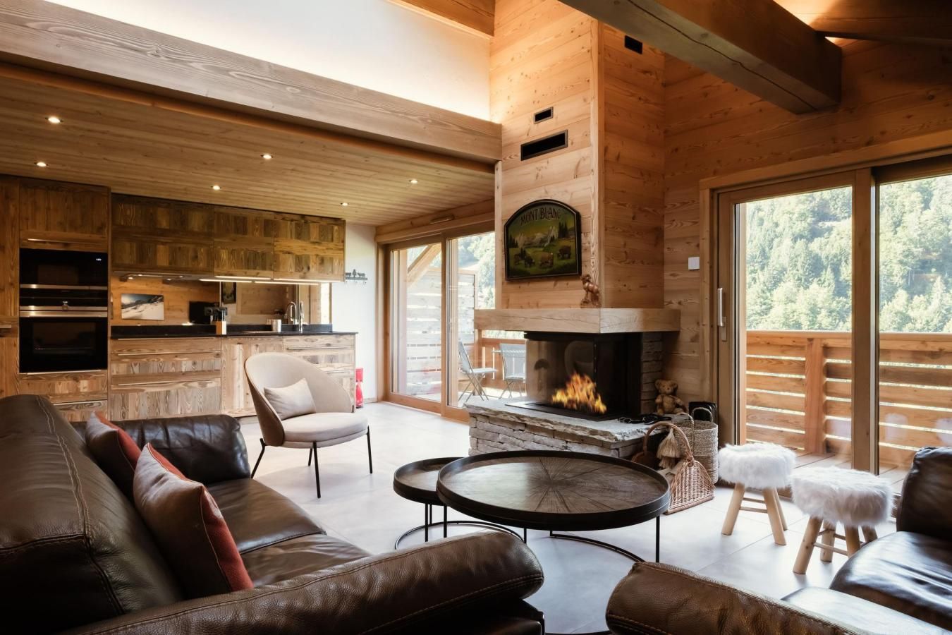 A cozy living room with a fireplace, leather sofa, and a dining area with a table and chairs.