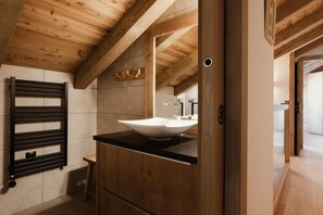 A modern bathroom with a wooden ceiling, a large white sink, and a black towel rack. - 1st floor, view mountain, balcony, fireplace or stove, tv, ski locker, 119m², La Clusaz (La Clusaz)
