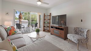 A living room with a sofa, armchair, TV, and a ceiling fan. - Fantastic 2-bedroom 2 bath condo for Seasonal Rent in Tequesta Fla (Tequesta)