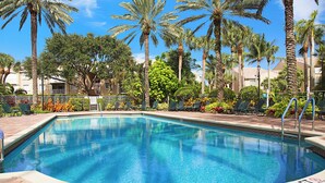 A rectangular swimming pool with a clear blue water, surrounded by palm trees and a paved walkway. - Fantastic 2-bedroom 2 bath condo for Seasonal Rent in Tequesta Fla (Tequesta)