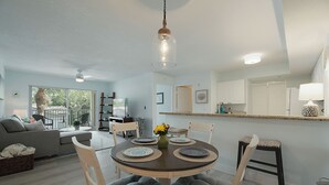 A modern dining area with a round table, chairs, and a vase of flowers. - Fantastic 2-bedroom 2 bath condo for Seasonal Rent in Tequesta Fla (Tequesta)