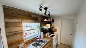 Una cocina con armarios de madera, encimera de granito, estufa y ventana con vistas a un jardín.