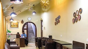 Un hall d’hôtel doté de sièges en cuir, d’un comptoir d’accueil et d’un escalier menant à l’étage supérieur.