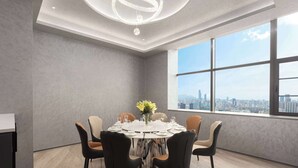 A modern dining room with a round table set for six, large windows with a city view, and a chandelier. - Days Inn By Wyndham Kunming Wujiaba (Kunming)