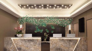 A reception area with marble counters, a decorative hanging element, and a central statue. - Days Inn By Wyndham Kunming Wujiaba (Kunming)