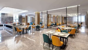 Uma sala de jantar moderna com várias mesas e cadeiras, uma ilha central com cozinha, e uma parede divisória de vidro.