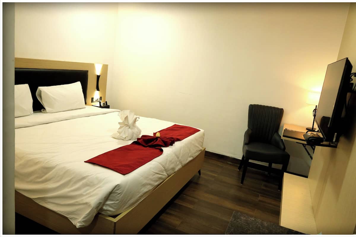 Relax in a cozy space with a comfortable bed, desk, and chair, perfect for work or unwinding.